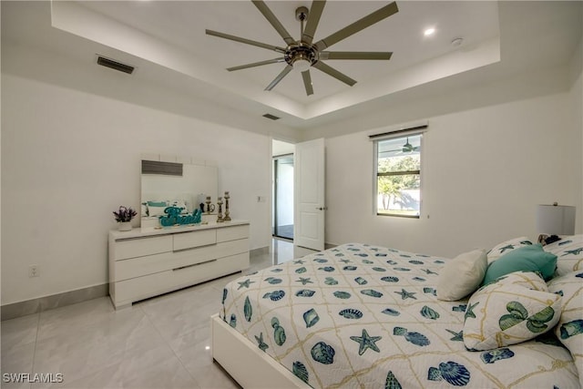 bedroom with ceiling fan and a tray ceiling