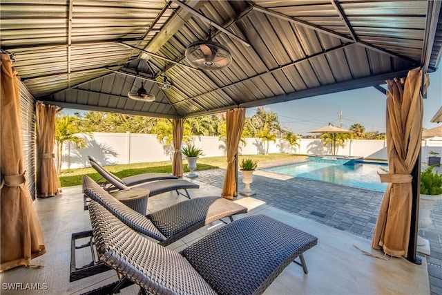 view of patio featuring a gazebo, ceiling fan, and a fenced in pool