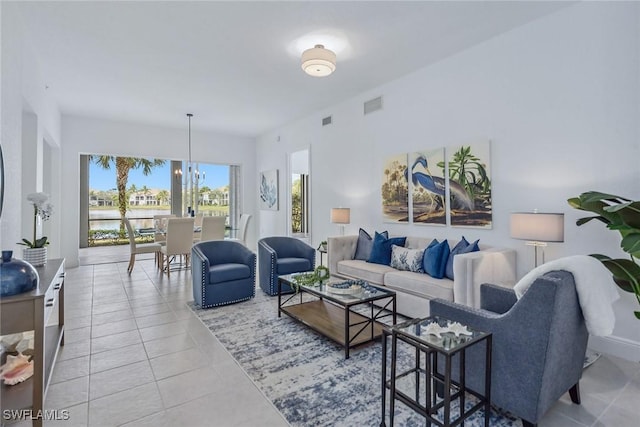 tiled living room with a water view and an inviting chandelier