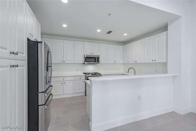 kitchen with light tile patterned floors, stainless steel appliances, sink, and white cabinets