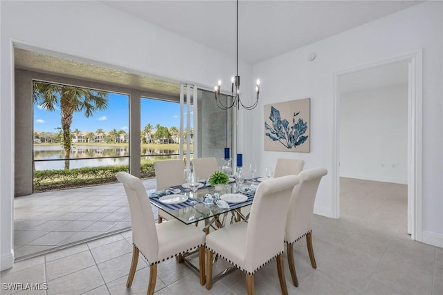 dining space featuring a water view, light tile patterned floors, and a notable chandelier