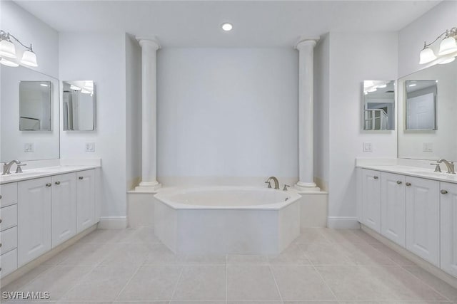 bathroom with decorative columns, vanity, a bath, and tile patterned floors