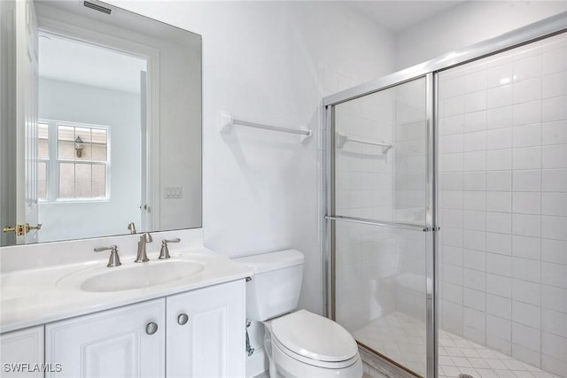 bathroom with toilet, vanity, and walk in shower