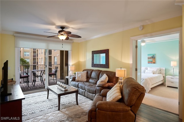 living area with wood finished floors, ornamental molding, and ceiling fan