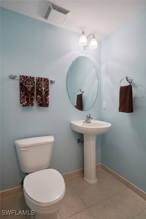 bathroom featuring tile patterned floors, visible vents, baseboards, and toilet