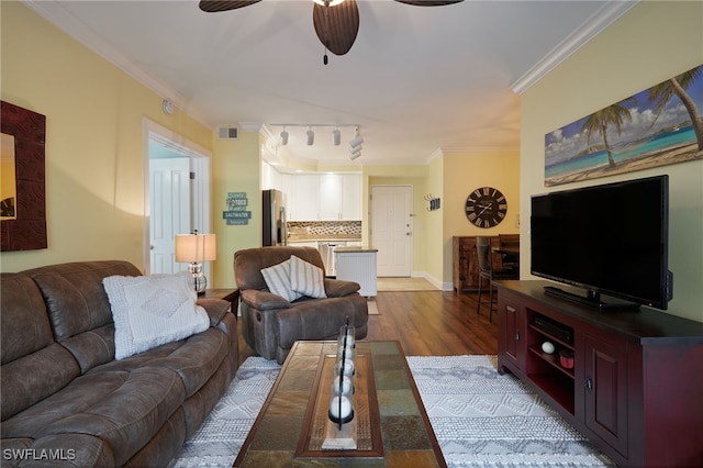 living area featuring light wood-type flooring, baseboards, visible vents, crown molding, and a ceiling fan