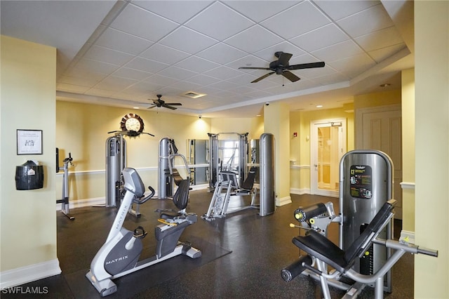 workout area featuring baseboards, a drop ceiling, and ceiling fan