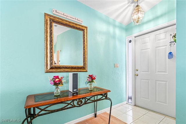 tiled foyer with a chandelier