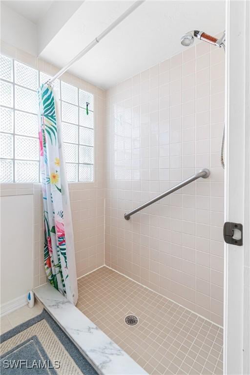 bathroom with a shower with curtain and tile patterned floors