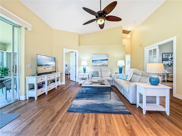 living room featuring ceiling fan, vaulted ceiling, and wood-type flooring