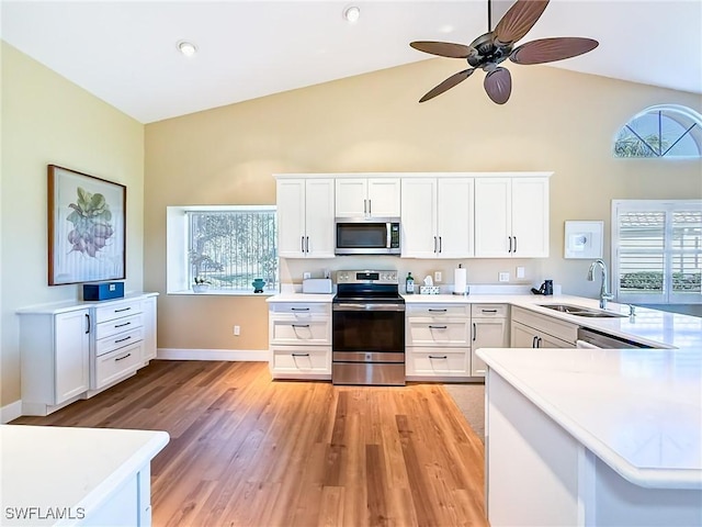 kitchen featuring white cabinetry, sink, kitchen peninsula, and appliances with stainless steel finishes