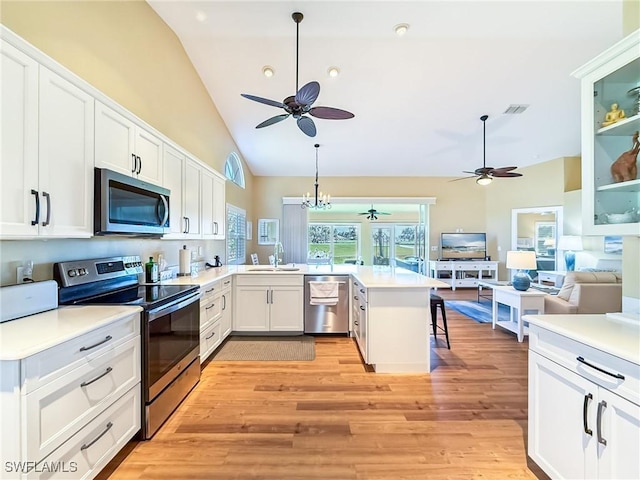 kitchen featuring sink, pendant lighting, a kitchen breakfast bar, stainless steel appliances, and white cabinets