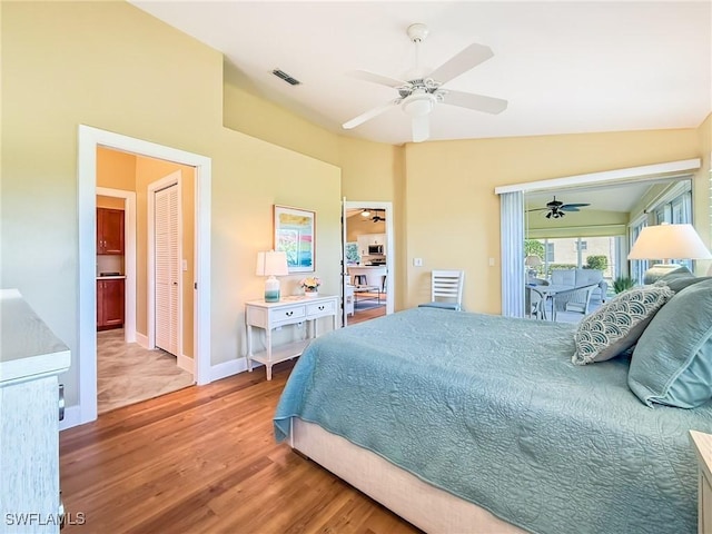 bedroom with access to exterior, hardwood / wood-style flooring, ceiling fan, and lofted ceiling