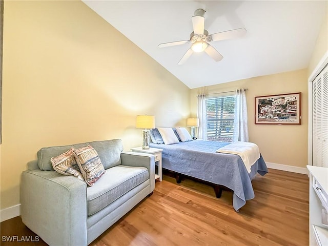 bedroom featuring vaulted ceiling, ceiling fan, light wood-type flooring, and a closet