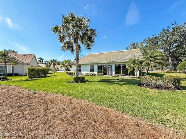 rear view of house featuring a yard