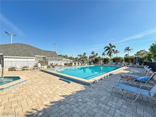 view of swimming pool with a patio and a hot tub