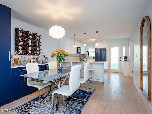 dining room with light wood-type flooring and visible vents