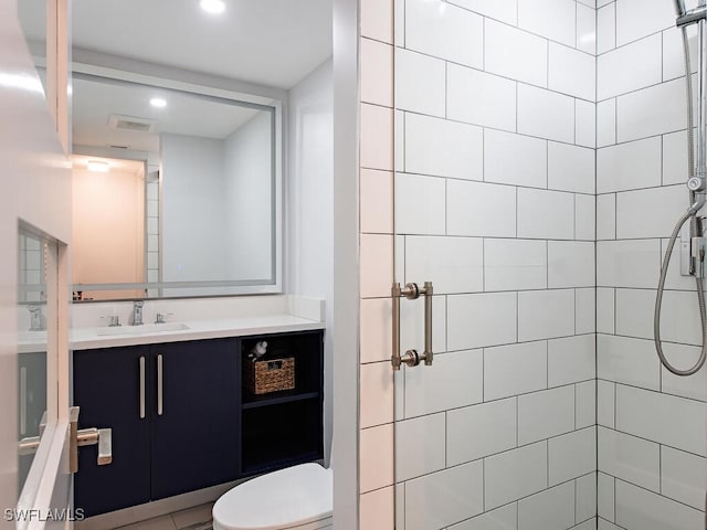 bathroom with toilet, a shower stall, vanity, and recessed lighting