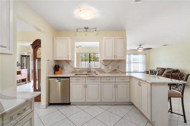 kitchen with tasteful backsplash, a wealth of natural light, dishwasher, and a sink