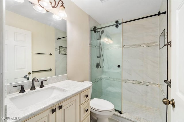 full bathroom featuring a shower stall, toilet, and vanity