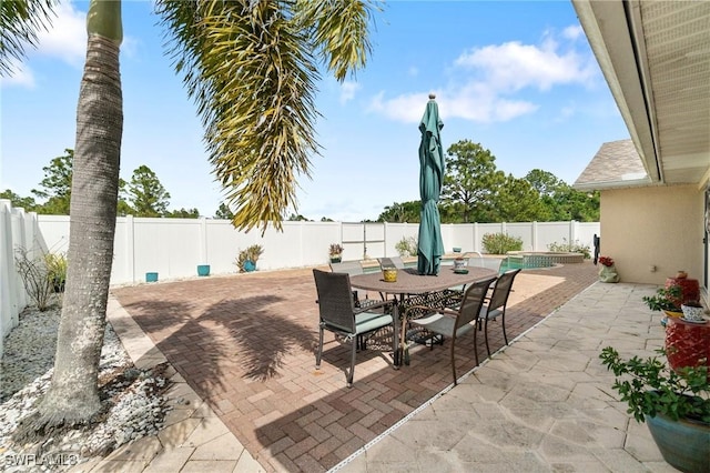 view of patio with a fenced in pool, outdoor dining space, and a fenced backyard