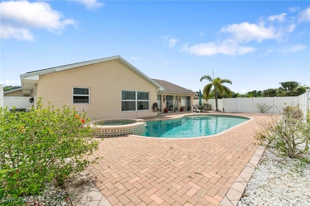 view of pool featuring a patio, a fenced backyard, and a pool with connected hot tub