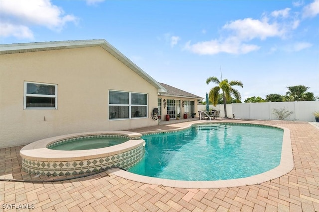 view of pool featuring a pool with connected hot tub, a patio area, and a fenced backyard