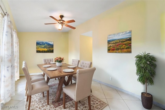 dining room featuring light tile patterned floors, a ceiling fan, and baseboards