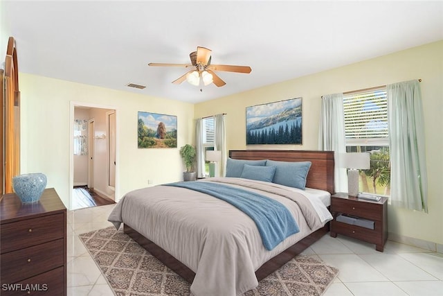 bedroom with light tile patterned floors, baseboards, visible vents, and a ceiling fan