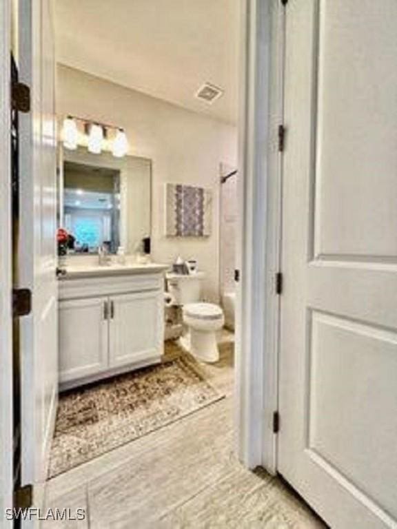 full bath featuring toilet, visible vents, and vanity