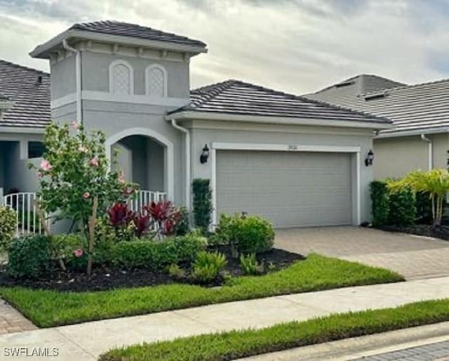 view of front of home featuring an attached garage, driveway, and stucco siding