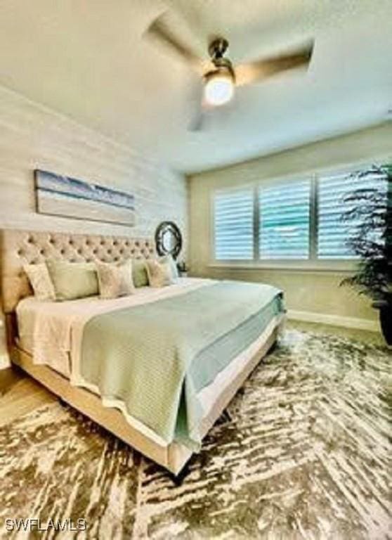 bedroom with ceiling fan and baseboards