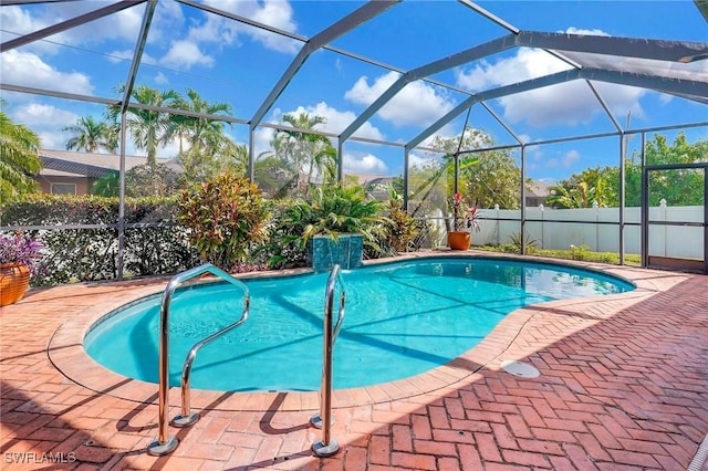 view of pool featuring pool water feature, glass enclosure, and a patio area