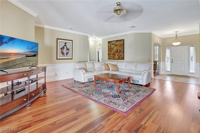 living room featuring ornamental molding, ceiling fan, and light hardwood / wood-style flooring