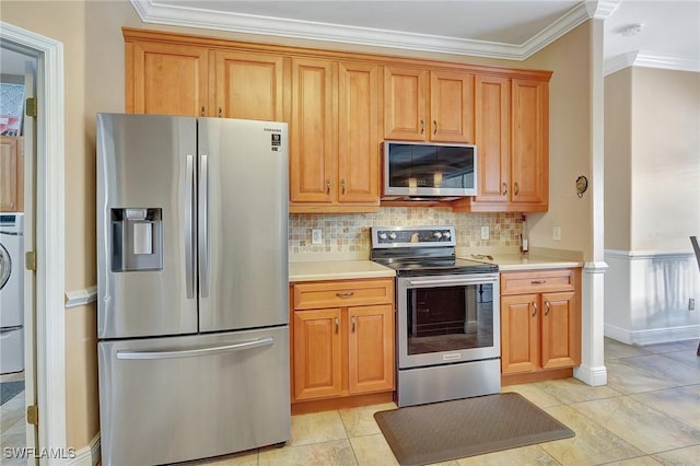 kitchen with washer / dryer, light tile patterned floors, ornamental molding, stainless steel appliances, and decorative backsplash