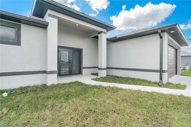 view of home's exterior featuring french doors, a yard, and a garage