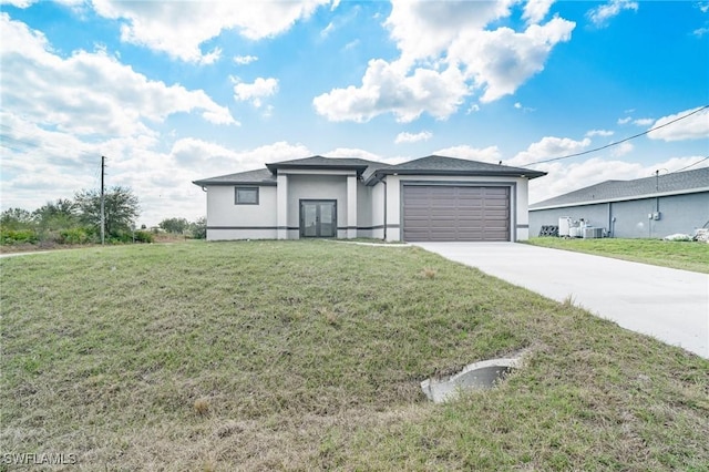 view of front of property with cooling unit, a garage, and a front yard