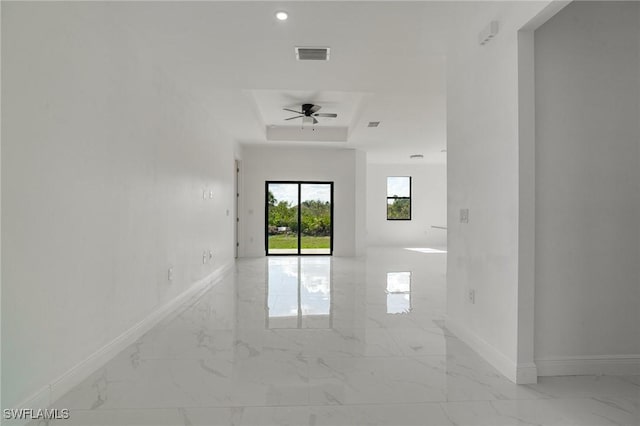 unfurnished room featuring ceiling fan and a tray ceiling