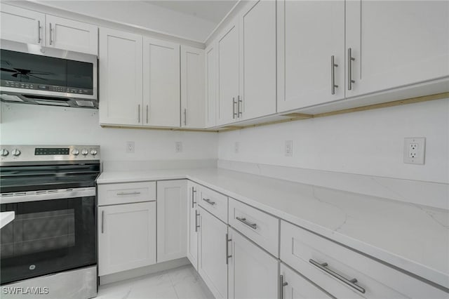 kitchen with white cabinetry, appliances with stainless steel finishes, and light stone counters