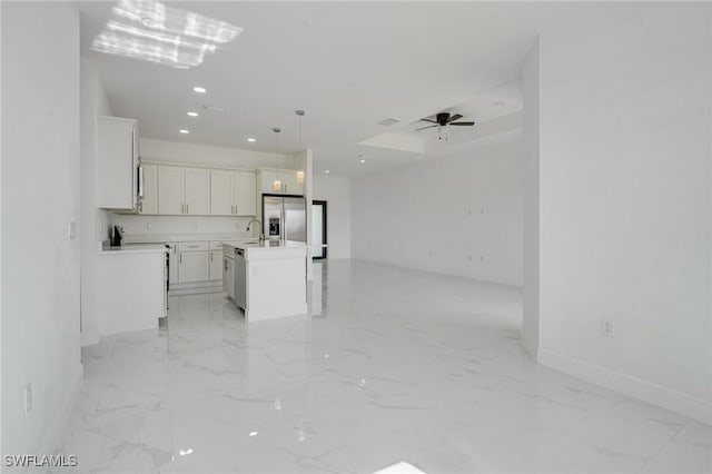 kitchen with sink, pendant lighting, stainless steel appliances, a kitchen island with sink, and white cabinets