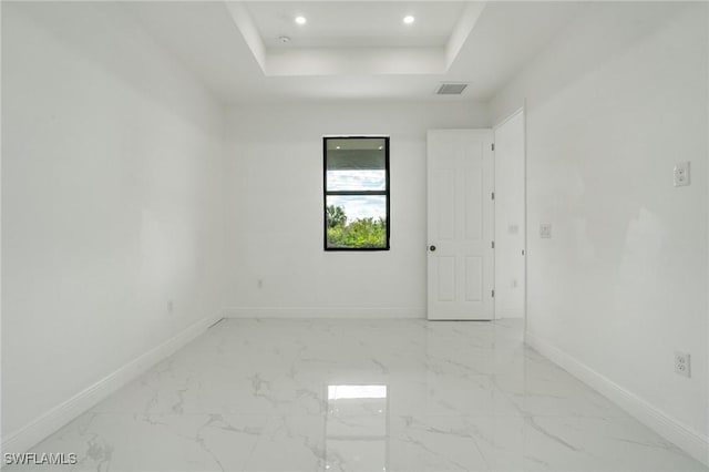 spare room with a tray ceiling