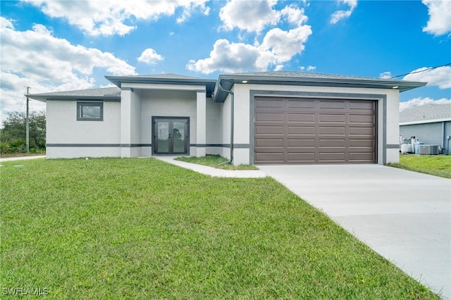 view of front of home with a garage, a front yard, and central air condition unit