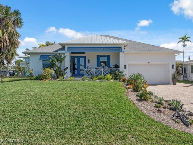 view of front of property featuring a garage, a porch, a front yard, and french doors