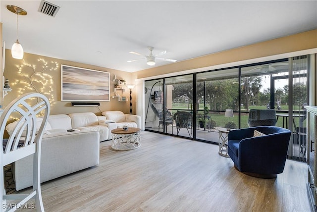 living room featuring wood-type flooring and ceiling fan