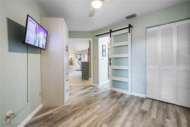 corridor with hardwood / wood-style flooring and a barn door