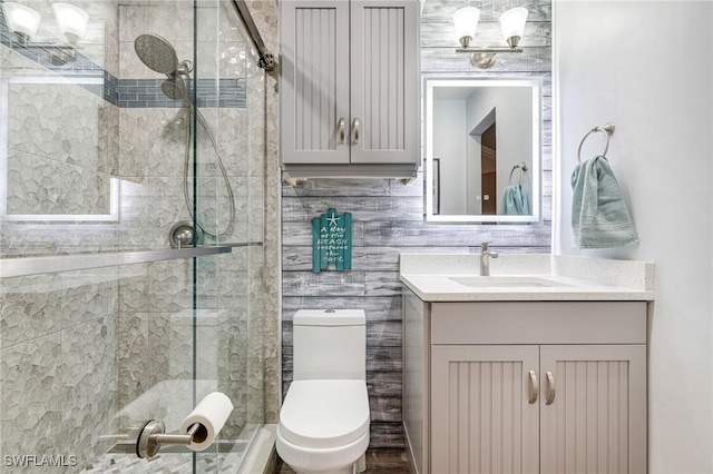 bathroom with vanity, tile walls, an enclosed shower, and toilet