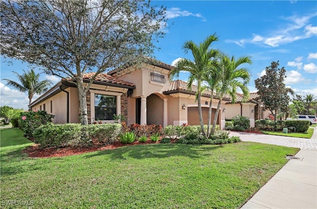 mediterranean / spanish home featuring a garage and a front lawn