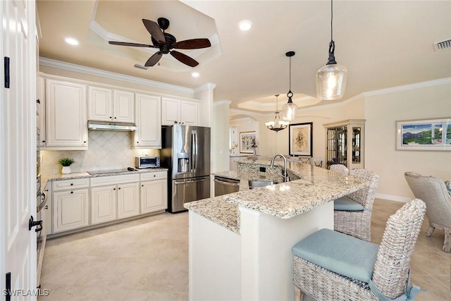 kitchen featuring sink, white cabinetry, hanging light fixtures, stainless steel appliances, and a raised ceiling