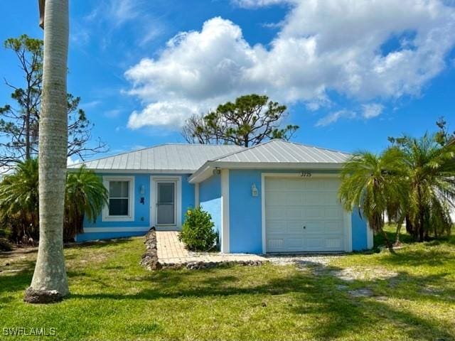 single story home with a garage and a front lawn