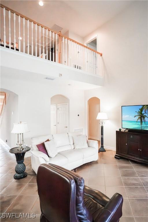 living room featuring tile patterned flooring and a towering ceiling